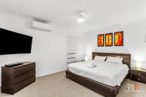 a bedroom with a bed and a flat screen tv at Amazing Location with Ocean View in Cowes