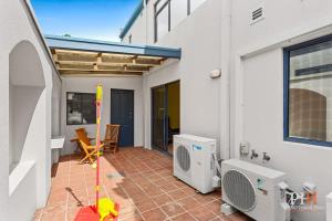 a home with a patio with a heater and a cat at Amazing Location with Ocean View in Cowes