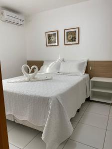 a white bed with a white towel on it at ILOA 02 quartos térreo 03J in Barra de São Miguel +12 photos
