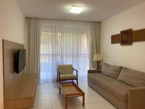 a living room with a couch and a chair at ILOA 02 quartos térreo 03J in Barra de São Miguel