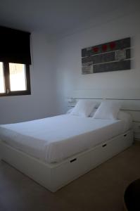 a white bed in a bedroom with a window at Villa Paraíso in Seville