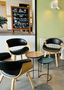 due sedie e tavoli in un ristorante con lavagna di Kyriad Toulouse Sud - Roques a Roques Sur Garonne