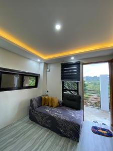 a living room with a couch in front of a window at Mountain Sunctuary-S2 Unit with Breathtaking view in Baguio +12 photos
