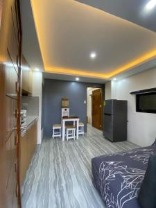 a room with a bed and a kitchen with a table at Mountain Sunctuary-S2 Unit with Breathtaking view in Baguio