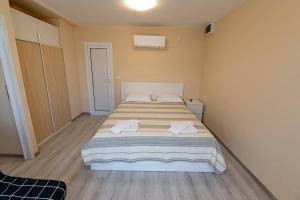 a bedroom with a large bed with towels on it at Хотелски комплекс САНЯ in Apriltsi