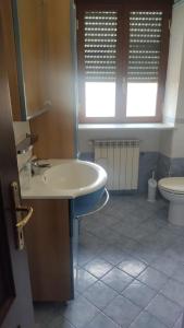 a bathroom with a sink and a toilet at Stanza in Villa in Torvaianica