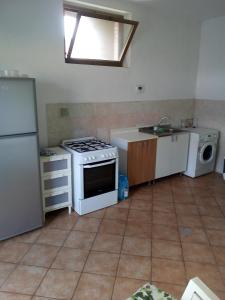 a kitchen with a stove and a refrigerator at Stanza in Villa in Torvaianica