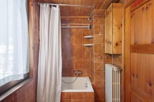 a bathroom with a tub and a shower curtain at Apartment Corti Garden in Campodolcino +18 photos