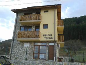 a building with a balcony on the side of it at Mini Complex Rilski Terasi in Sapareva Banya