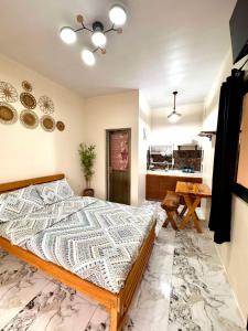 a bedroom with a large bed and a kitchen at Mountain Sunctuary-LH Solo Unit for couple in Baguio