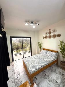 a bedroom with a bed and a large window at Mountain Sunctuary-LH Solo Unit for couple in Baguio