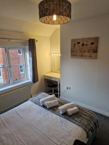 een slaapkamer met een bed met twee handdoeken erop bij Hereford - Mayflower Coach House, Modern 2 Bedroom Property With Parking, Located South Of Hereford City, Suitable For Small Family, Couple Or Contractors - Sleeps Up To 5 Guests - Hosted by RENTMYHOUSE in Hereford +11 foto's