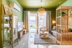 salon z zielonymi ścianami i kanapą w obiekcie Sunstone - Cozy Studio W Terrace in Larnaca w Larnace