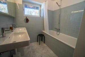 y baño con lavabo, ducha, bañera y lavamanos. en Chalet Choucas, en Gryon 18 fotos más