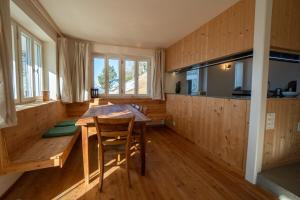 Una cocina con una mesa y sillas de madera en una habitación. en Chalet Choucas, en Gryon