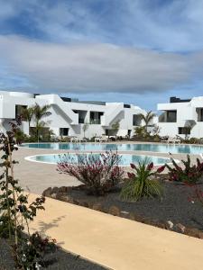 a view of a resort with a swimming pool at Casita Oliva - Piso de diseño en Fuerteventura in La Oliva
