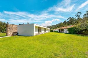 a large yard with a white building in a field at Portugal Active Oliveiras Farm in Viana do Castelo