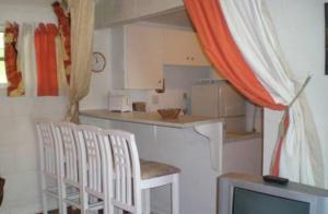 a kitchen with four white chairs and a television at The Legend Garden Condos in Saint Peter
