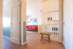 a living room with a red couch and a chair at BlueGreen Beach Apartment in Viana do Castelo