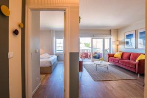 a living room with a red couch and a bed at BlueGreen Beach Apartment in Viana do Castelo +14 photos