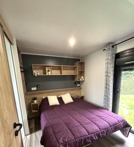 a bedroom with a purple bed and a window at Camping de Keranterec in La Forêt-Fouesnant