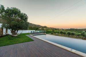 una piscina con un árbol y una hamaca en una casa en Portugal Active Montaria Lodge, en Montaria