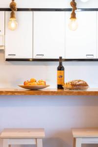 a bottle of wine and a plate of oranges on a counter at Divine Waves Duplex by Portugal Active in Viana do Castelo