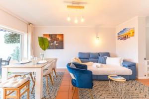 a living room with a blue couch and a table at Divine Waves Duplex by Portugal Active in Viana do Castelo