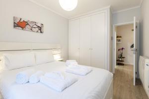 a bedroom with a white bed with towels on it at Divine Waves Duplex by Portugal Active in Viana do Castelo