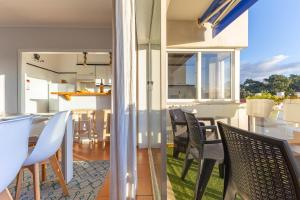 a kitchen and dining room with chairs and a table at Divine Waves Duplex by Portugal Active in Viana do Castelo