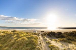 a walkway to the beach with the sun setting at Tide Terrace Duplex by Portugal Active in Viana do Castelo