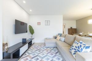 a living room with a couch and a flat screen tv at Tide Terrace Duplex by Portugal Active in Viana do Castelo +59 photos