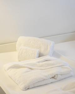 two towels are stacked on top of a bed at Tide Terrace Duplex by Portugal Active in Viana do Castelo