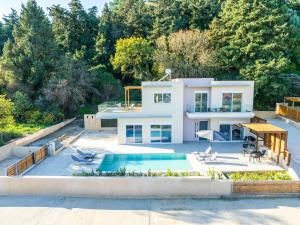 a house with a swimming pool and a backyard at Villa Anastazia in Koskinou