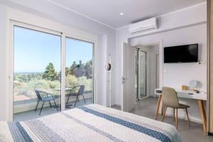a bedroom with a bed and a desk and a balcony at Villa Anastazia in Koskinou