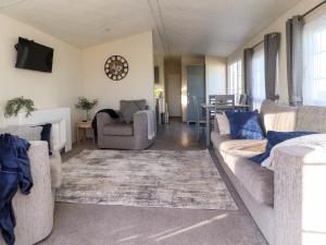 a living room with two couches and a tv at 17 Birchwood Close in Brown Moss Side