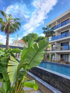 a resort with a swimming pool and palm trees at No 22 Çeşme in Çeşme +14 photos