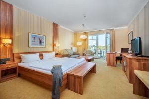 a hotel room with a bed and a television at Strandhotel garni Kormoran in Zinnowitz