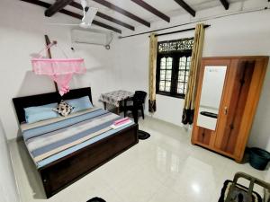 een slaapkamer met een bed, een tafel en een raam bij Mango Shade Weligama in Weligama