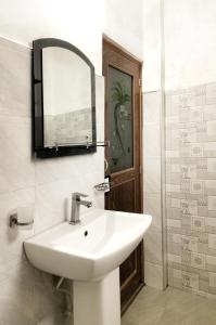 een badkamer met een wastafel en een spiegel aan de muur bij Mango Shade Weligama in Weligama