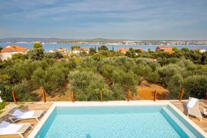 a swimming pool with a view of the water at Villa Santa Lucia ZadarVillas in Turanj