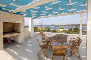 a patio with a table and chairs and a fireplace at Villa Santa Lucia ZadarVillas in Turanj