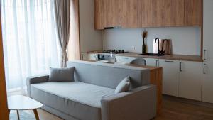 a living room with a couch and a kitchen at Cozy Apartments - Ared UTA Flat in Arad
