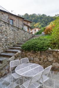 un tavolo e sedie seduti accanto a un muro di pietra di Torretta della Pescalina - Pescate - Lecco a Pescate