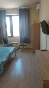 a room with two chairs and a bed and a television at Цар Освободител 108 in Ruse