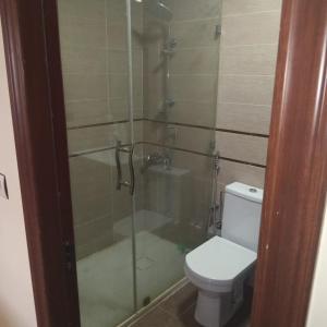 a bathroom with a toilet and a glass shower at Dar lara in Larache