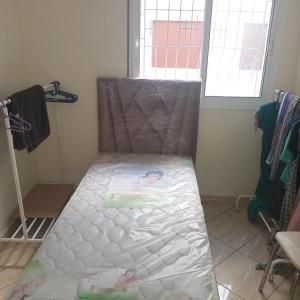 a bed sitting in a room with a window at Dar lara in Larache