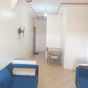 a living room with a blue couch and a table at Dar lara in Larache