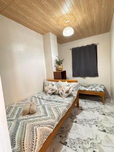 a room with two beds with pillows on it at Mountain Sunctuary-TD Solo Unit for friends and family in Baguio