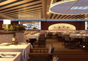 a dining room with white tables and chairs and a restaurant at Hôtel Barrière Le Majestic Cannes in Cannes